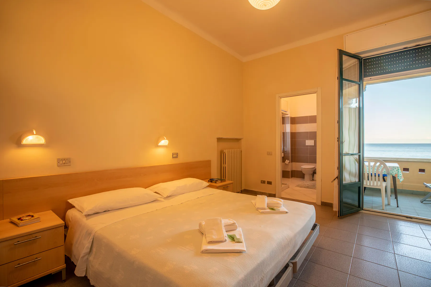 Double room with a double bed and a French window open onto a sea-view balcony