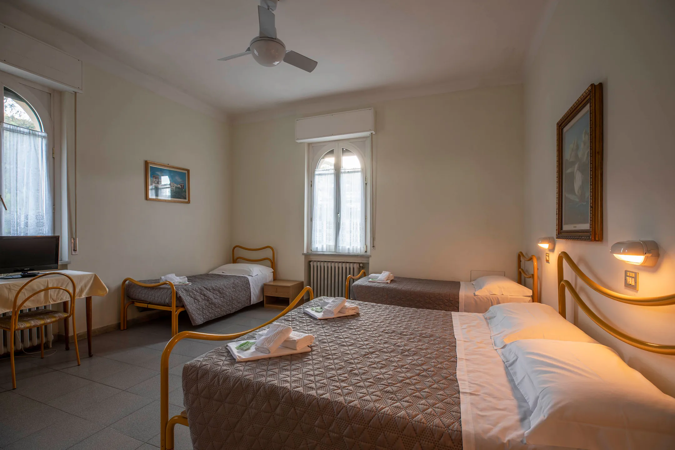 Quadruple room with a double bed, two single beds and arched windows