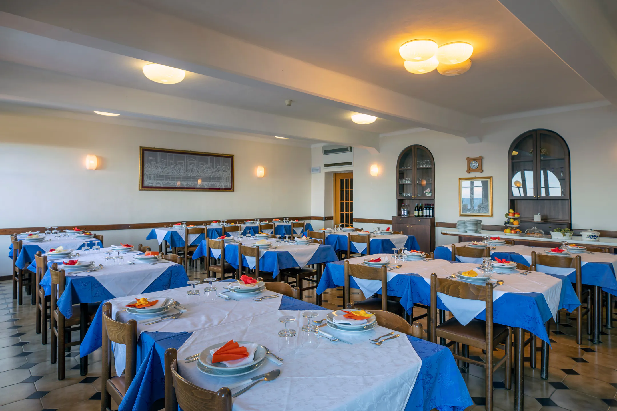 La sala da pranzo con tovaglie bianche e blu e tavoli apparecchiati