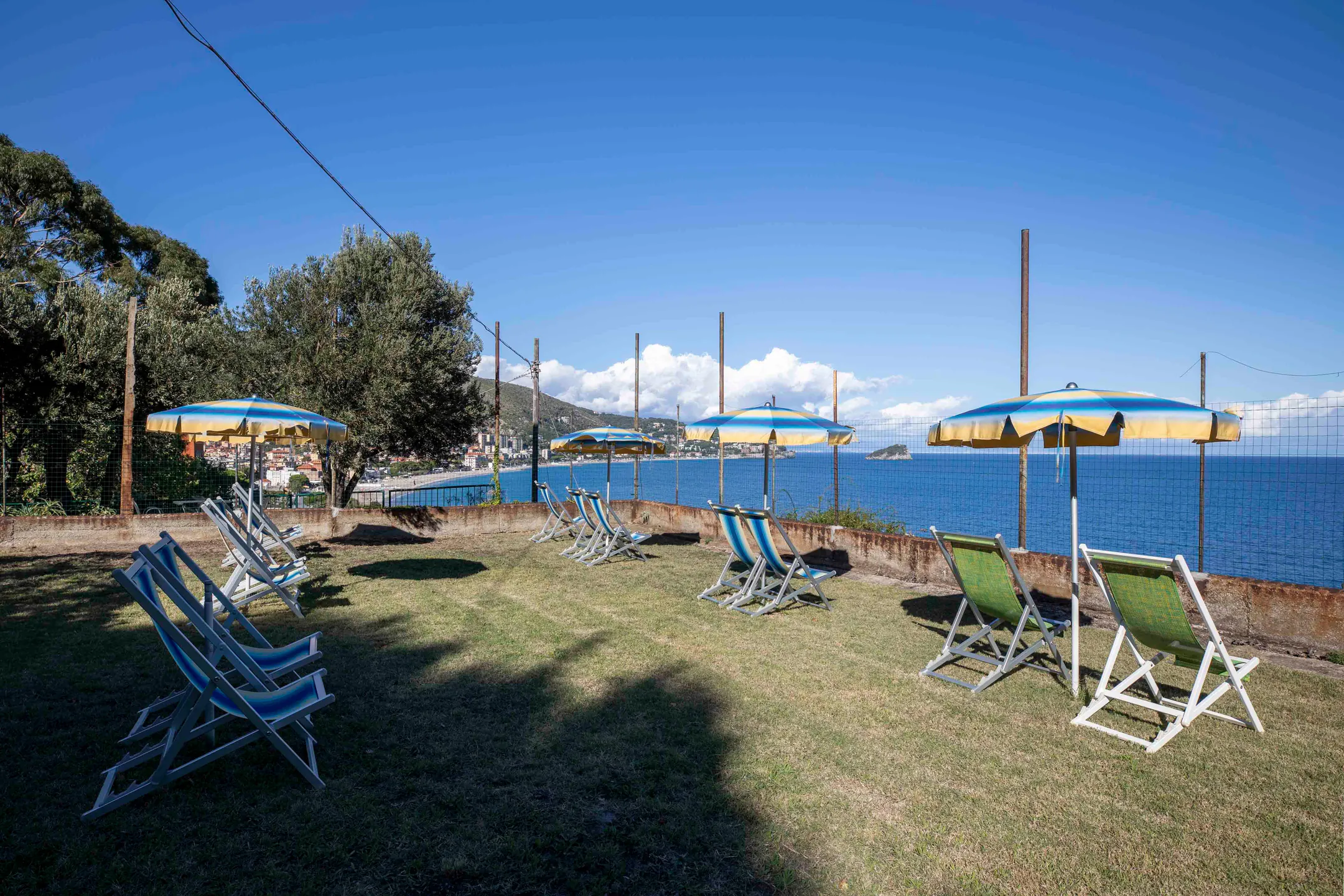 The Garden Beach: a lawn with deck chairs and umbrellas above the sea
