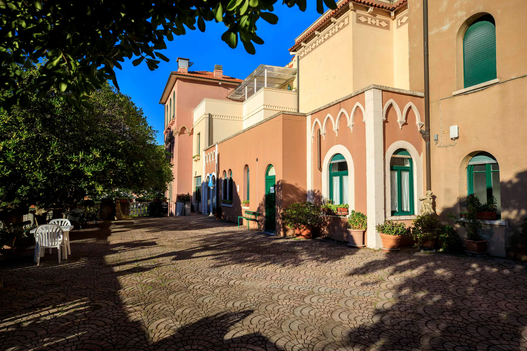 La terrazza lastricata davanti agli edifici della casa, con piante in vaso